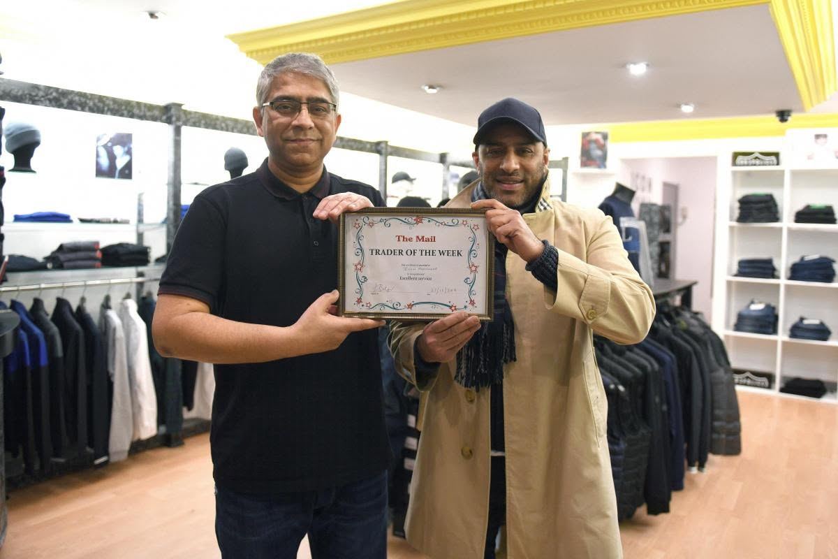The Icon Menswear team holding The Mail Trader of the Week certificate inside the shop