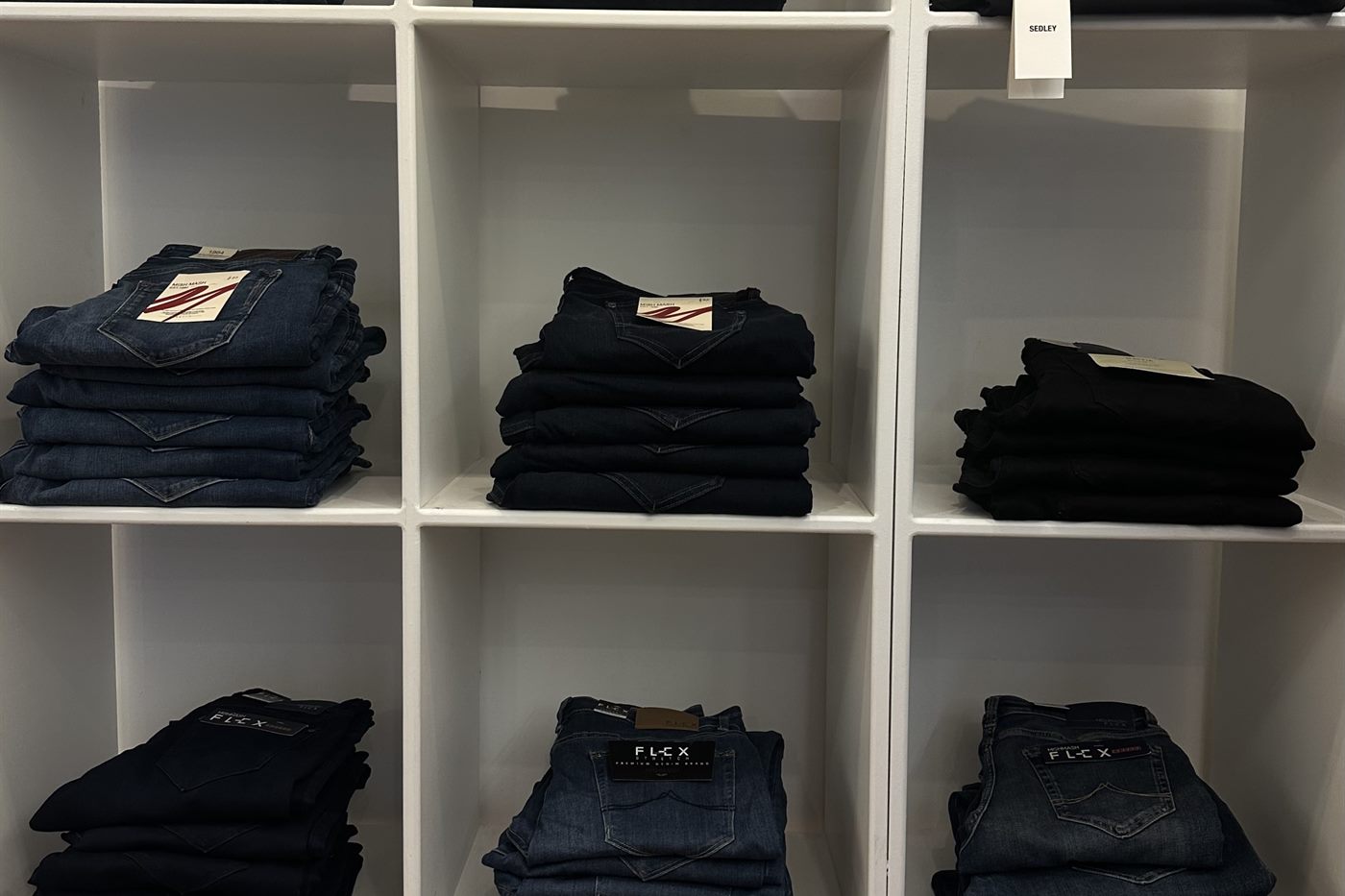Folded jeans and denim on the shelves at Icon Menswear